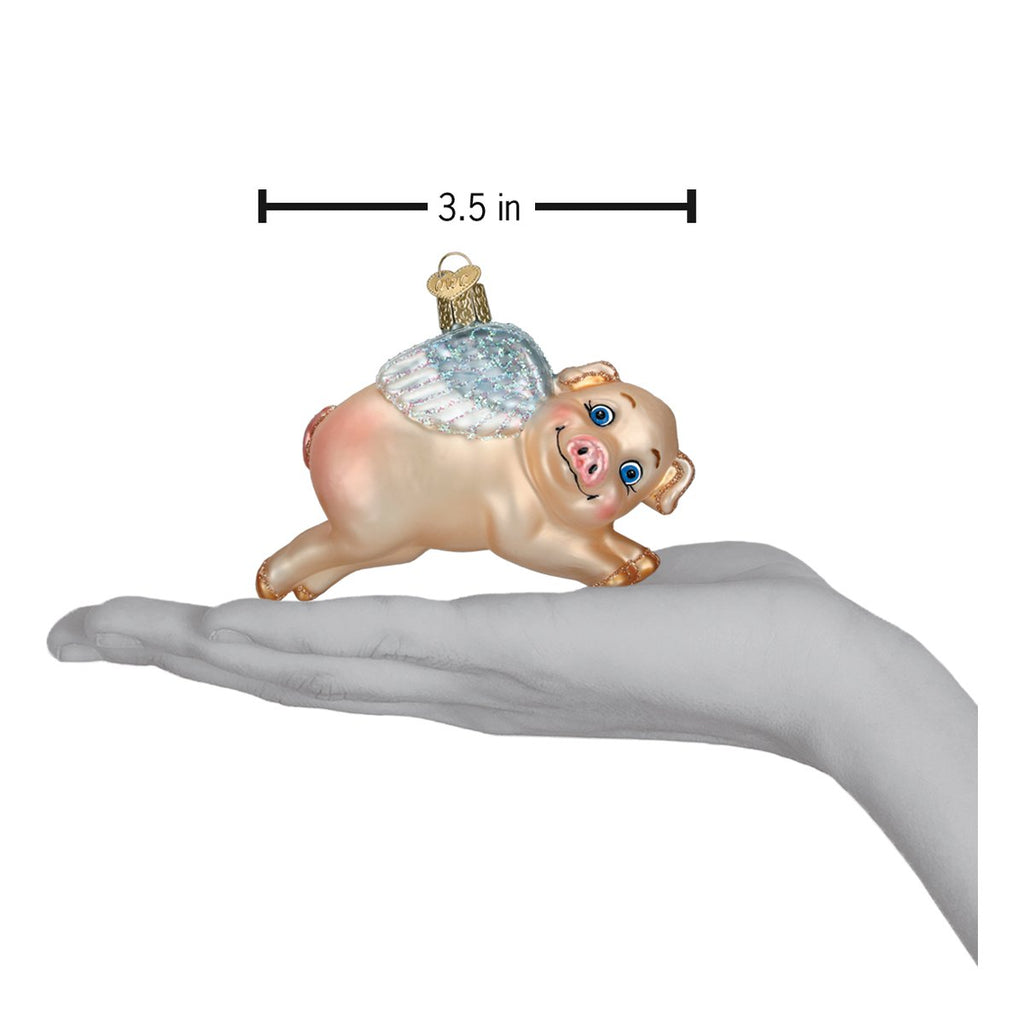 Flying Pig Glass Ornament held in hand, showcasing handcrafted artisan decor with playful charm.