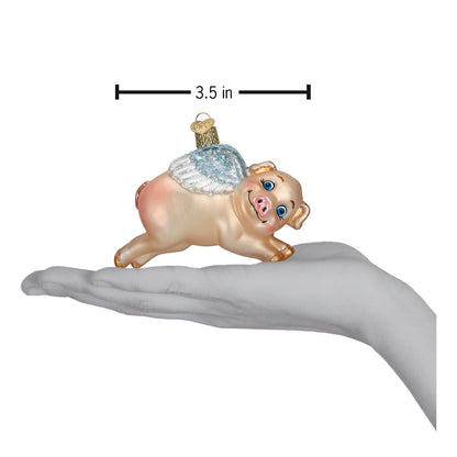 Flying Pig Glass Ornament held in hand, showcasing handcrafted artisan decor with playful charm.