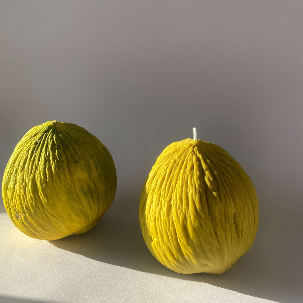 Two artisan handcrafted Casaba Melon Candles in vibrant yellow, adding a unique decor touch to any space.