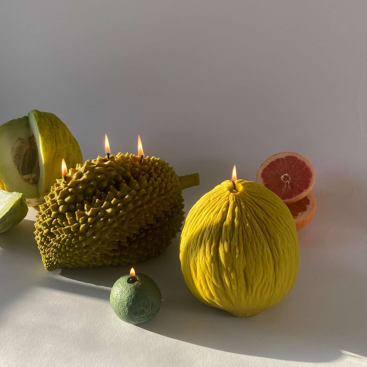 Artisan Casaba Melon Candle surrounded by handcrafted fruit candles, adding a touch of decor to your space.