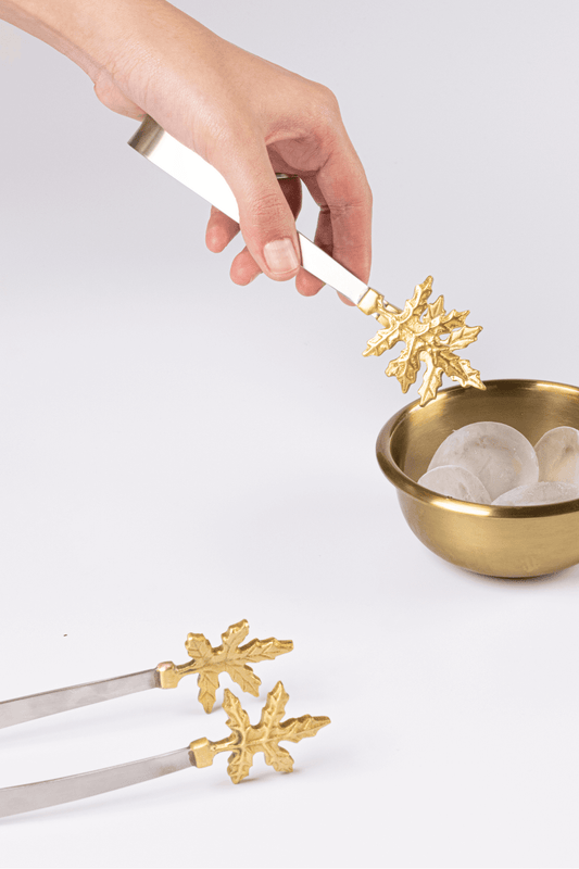 Brass Leaf Tongs elegantly serving ice cubes in a stylish bowl, showcasing artisan design and handcrafted beauty.