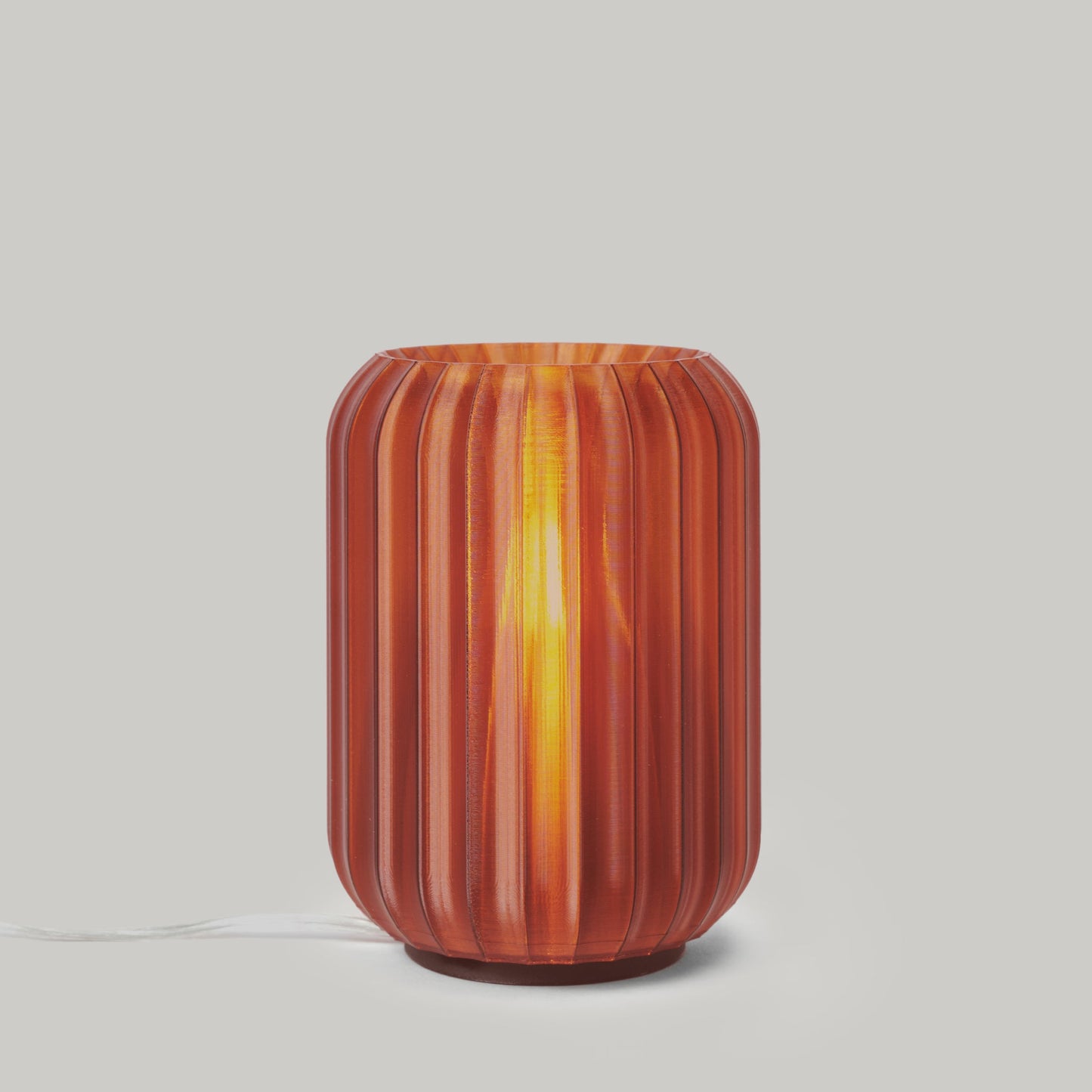 Mini Allium Lamp in vibrant orange, showcasing its sculptural design and soft ambient light.