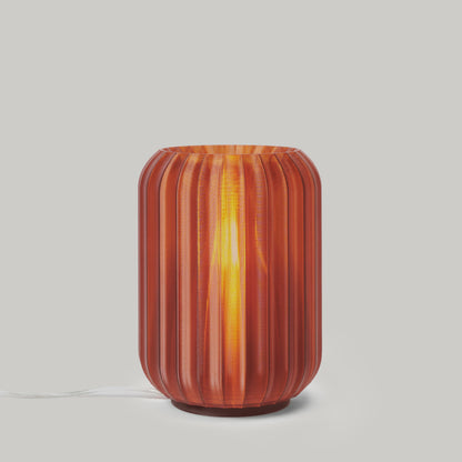 Mini Allium Lamp in vibrant orange, showcasing its sculptural design and soft ambient light.