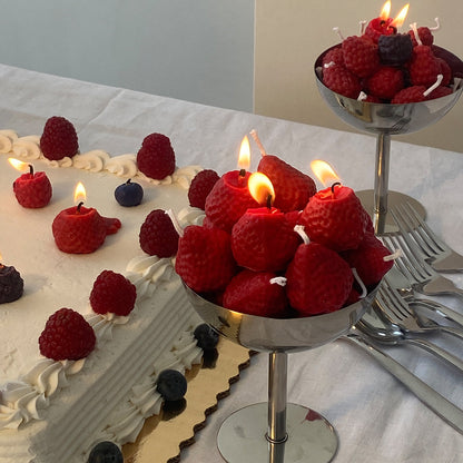 Strawberry Candles - 8 Pack displayed on a cake and in bowls, perfect artisan decor for any celebration.